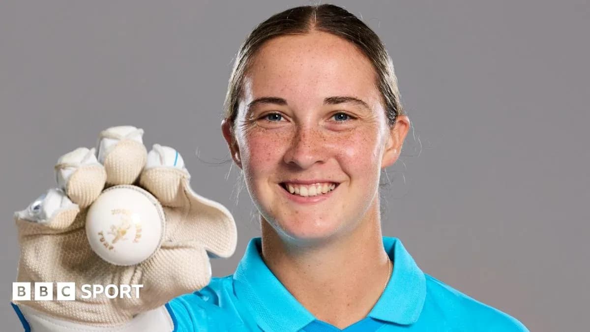 Cricketer holding a ball and smiling
