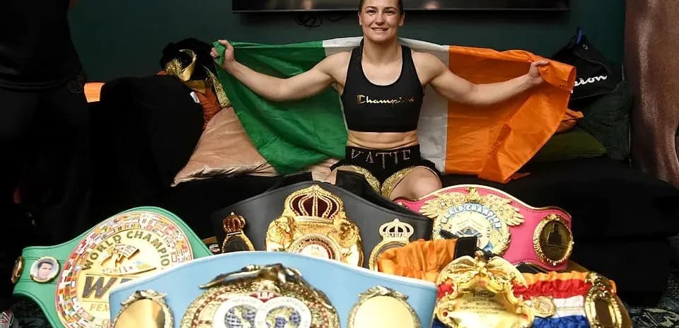 Boxer holding Irish flag with championship belts