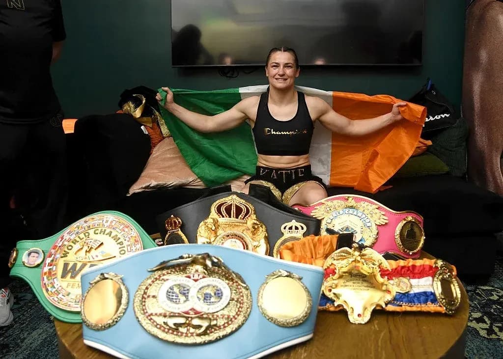 Boxer holding Irish flag with championship belts