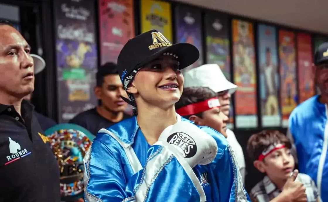 Young female boxer smiling with gloves and supporters