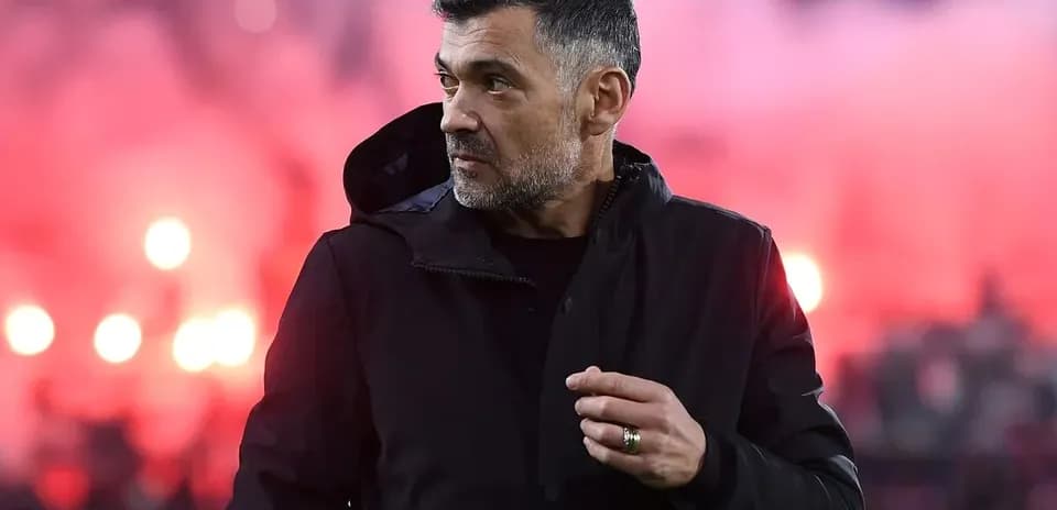 Coach observing match with colorful smoke in background