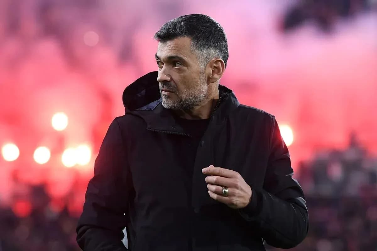 Coach observing match with colorful smoke in background