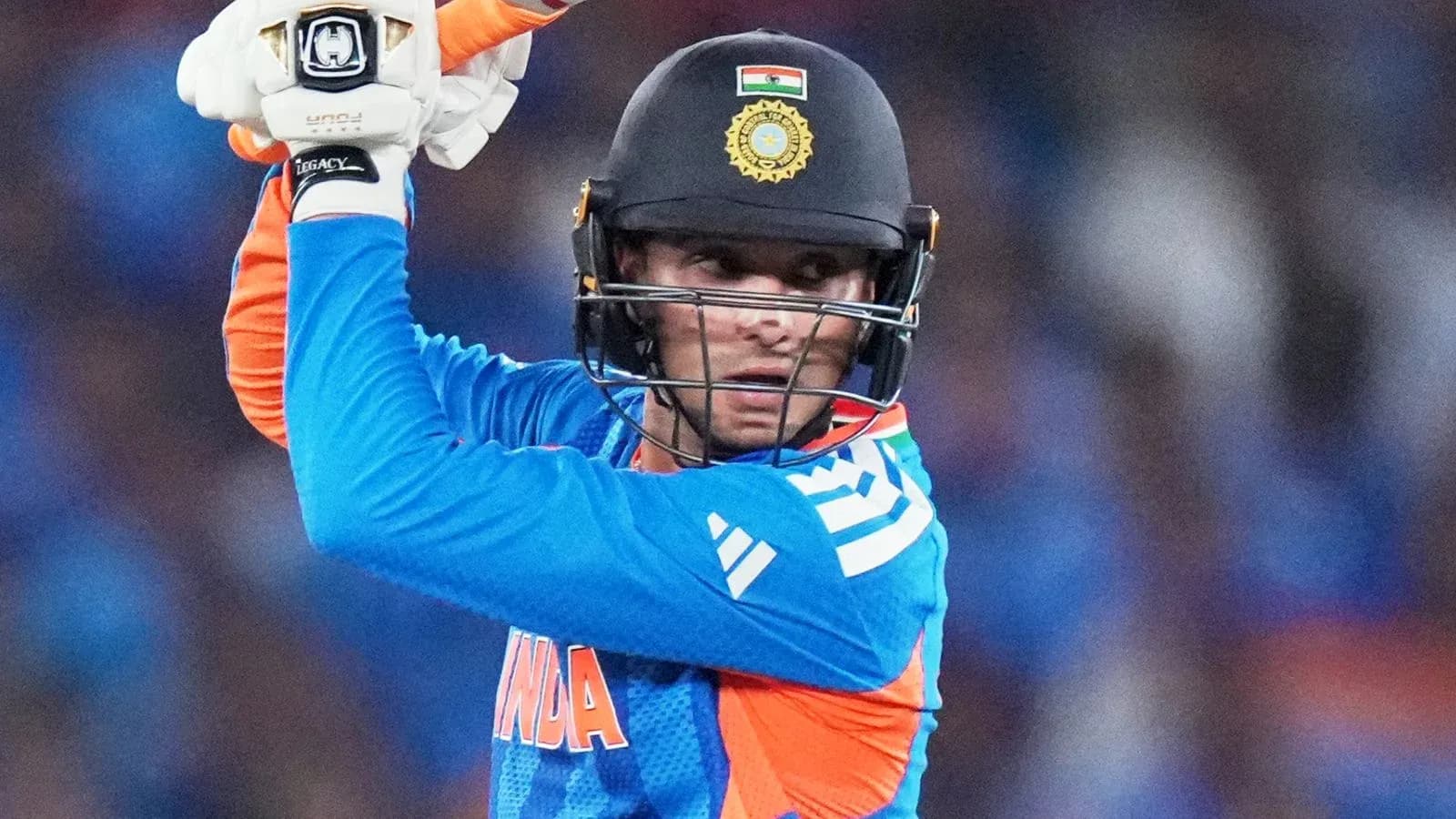 Cricketer preparing to bat in blue uniform