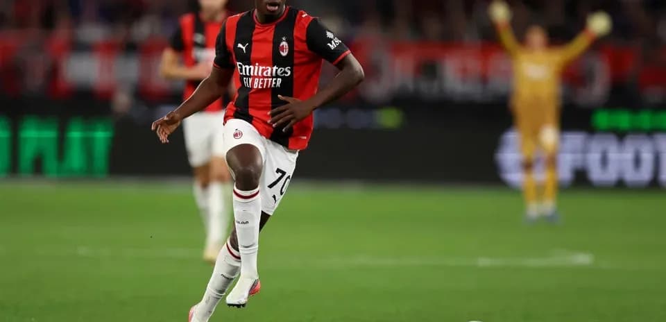 Player running with ball during match for AC Milan