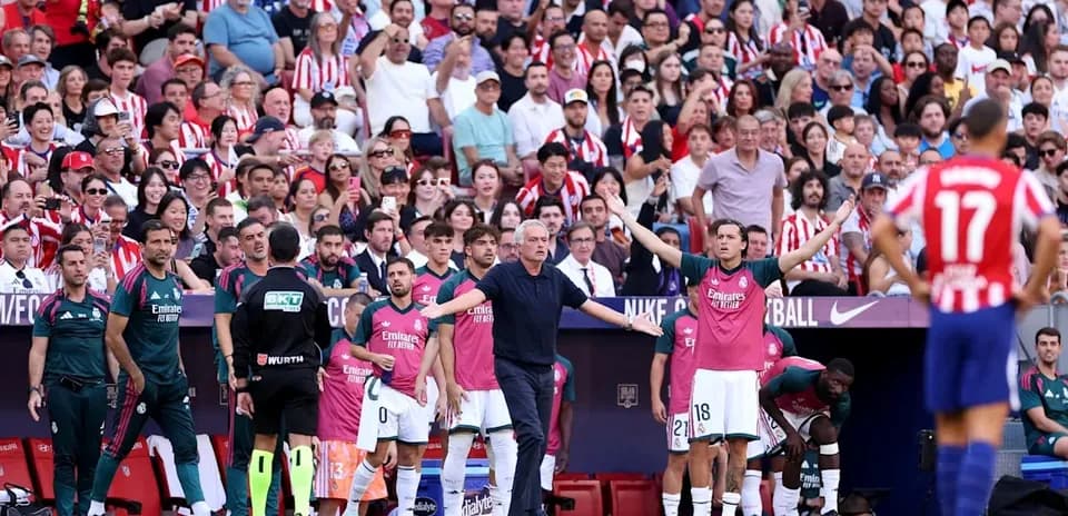 Manager gesturing to players on the sidelines during match