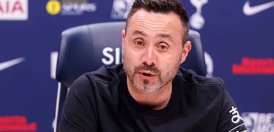 Manager speaking at press conference with team logo