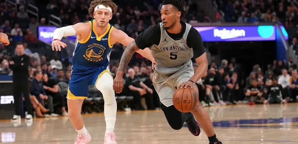 Player from San Antonio dribbling past Golden State defender