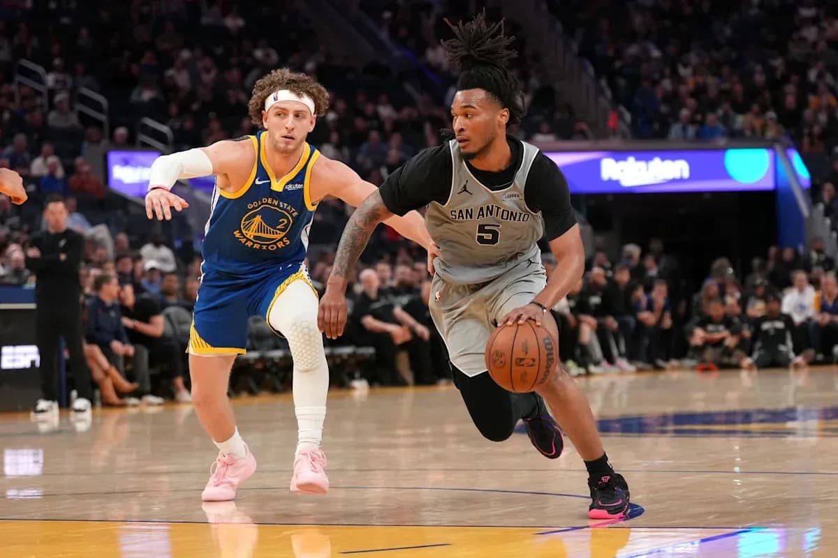 Player from San Antonio dribbling past Golden State defender