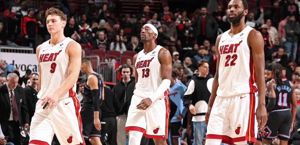 Three Miami Heat players walking off the court