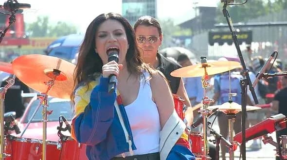 Singer performing on stage with a band