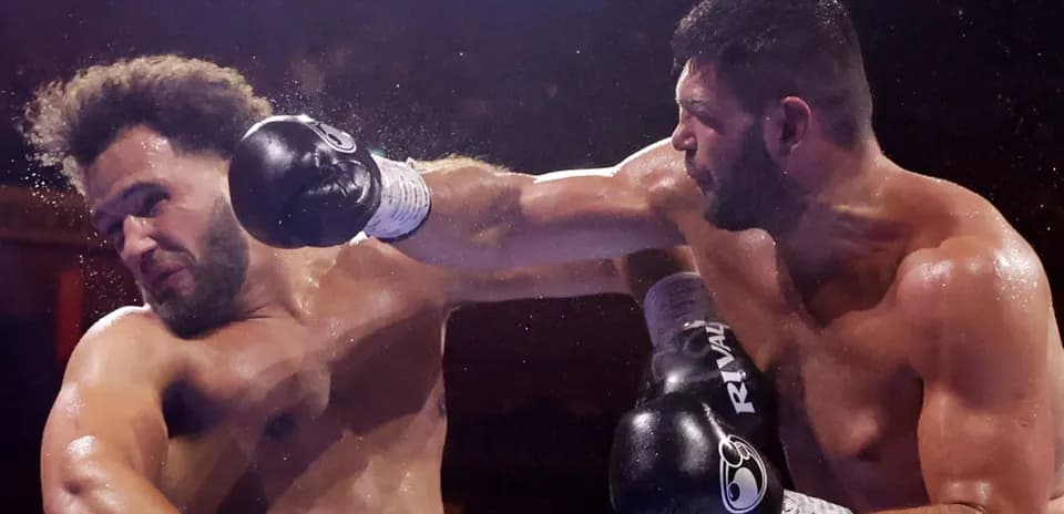 Two boxers engaged in a match, one delivering a punch