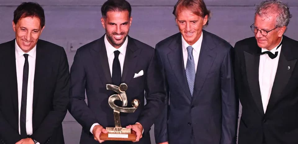 Group of four men holding an award at event