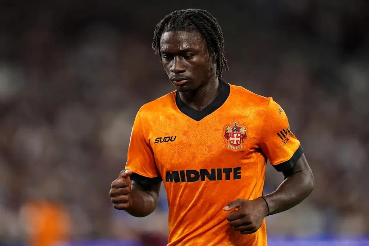 Player in orange jersey walking on the pitch