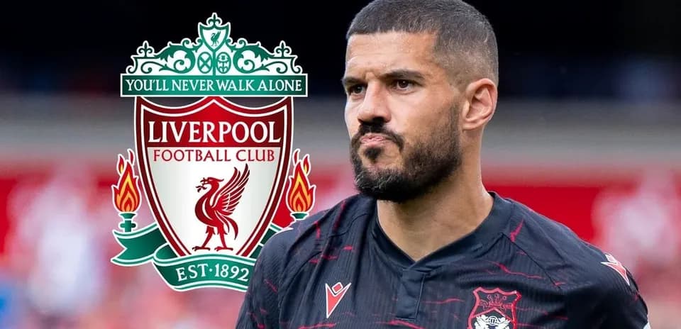 Player in Liverpool FC jersey near club logo