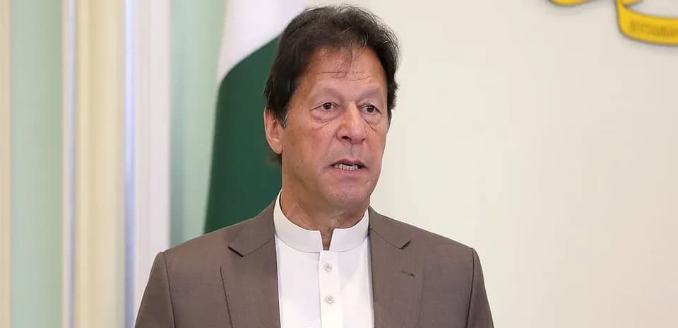 Person speaking at a podium with national flag behind