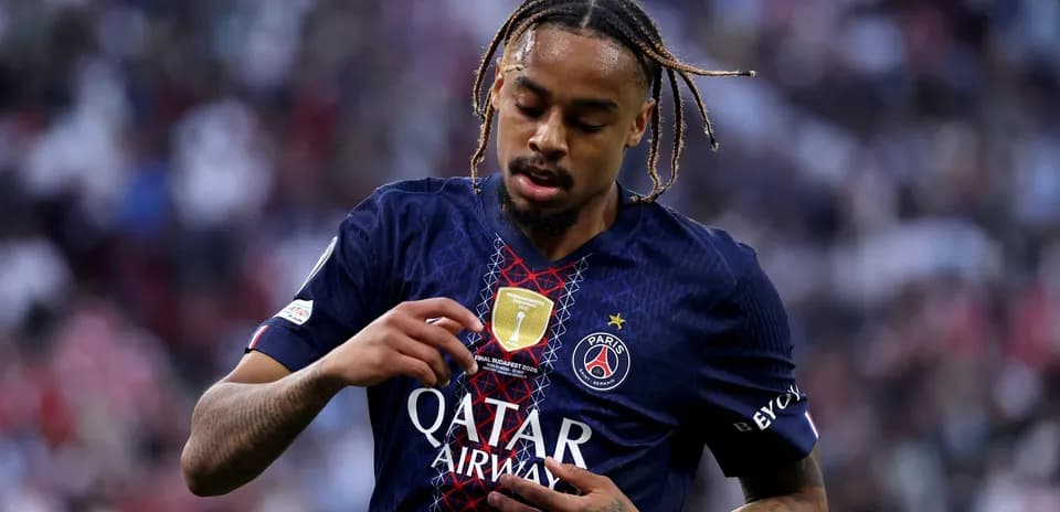 Player inspecting badge on Paris Saint-Germain jersey