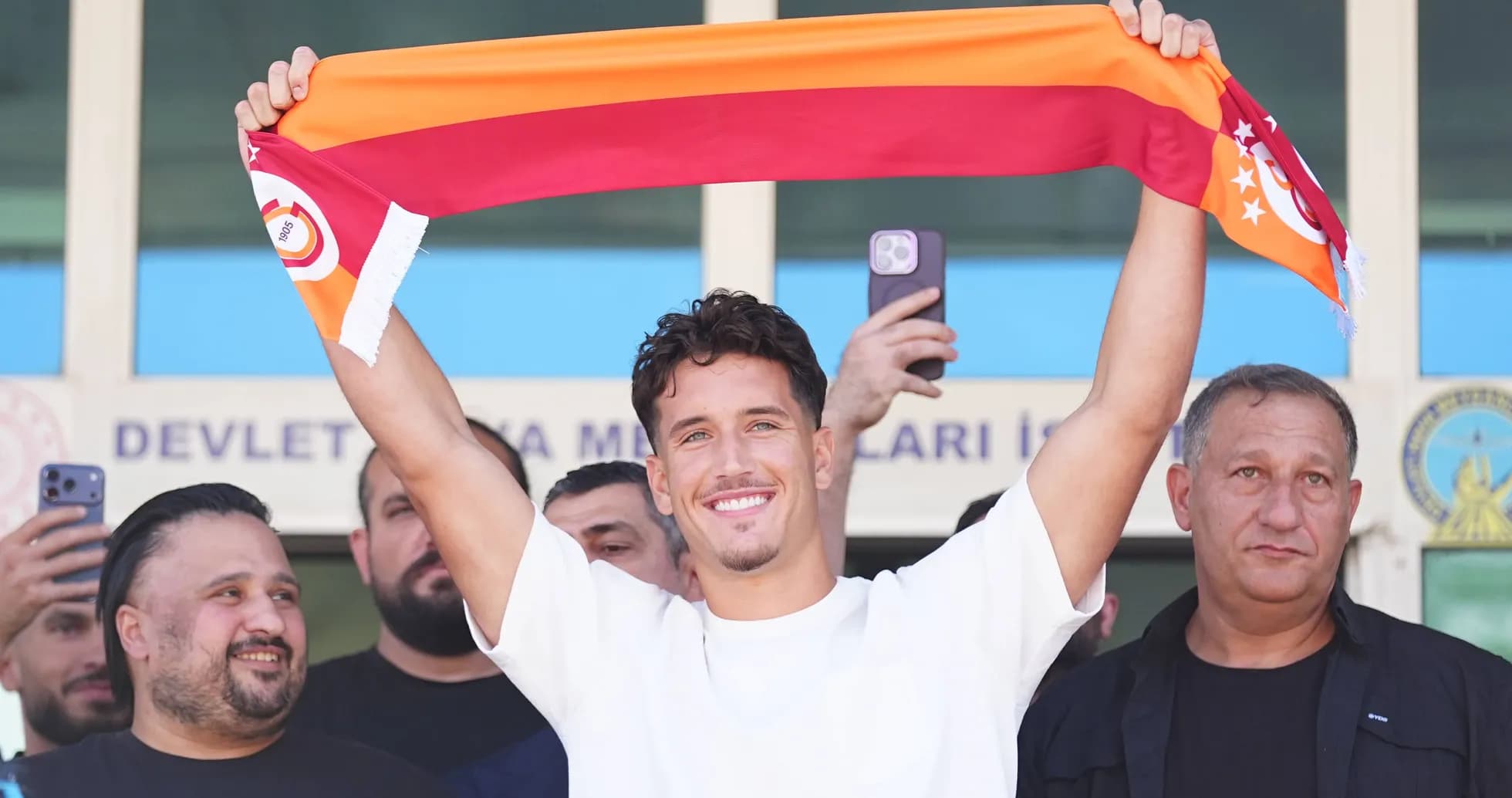 Player holding Galatasaray scarf during announcement event