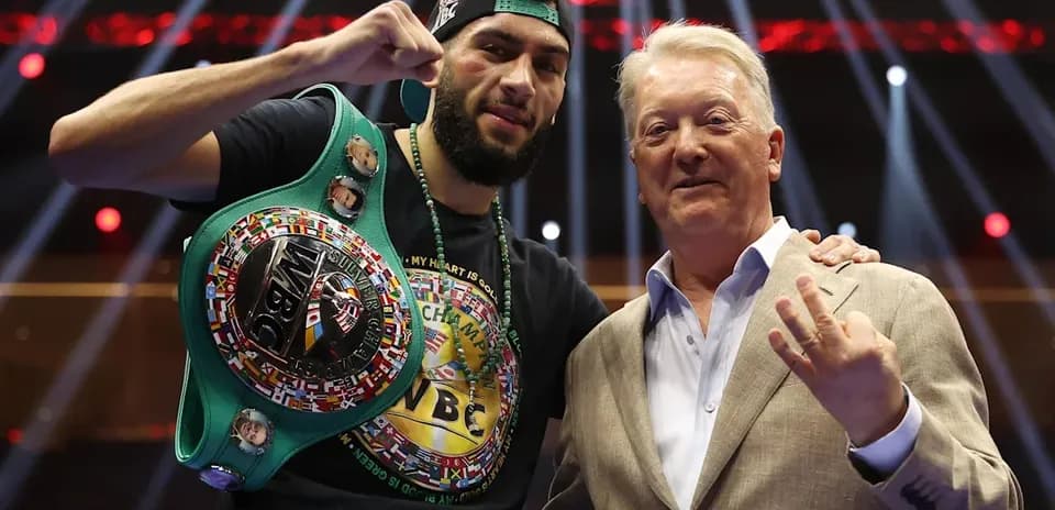 Boxer holding WBC belt with promoter in ring
