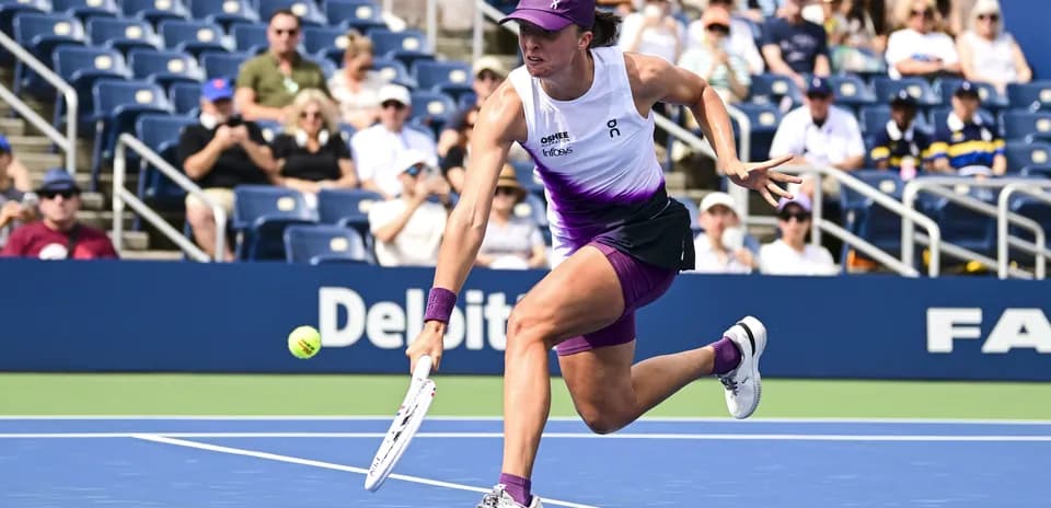 Player reaching for a tennis ball during match