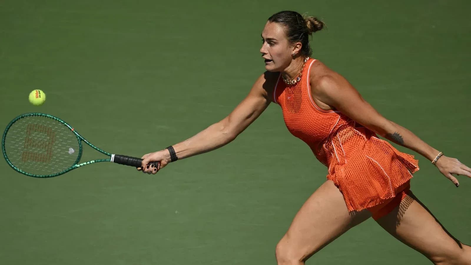 Female tennis player reaching for a ball