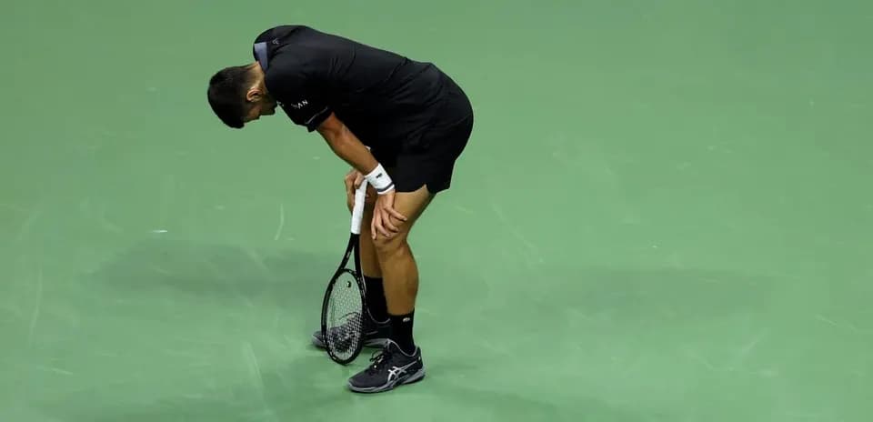 Tennis player bending over on court after point