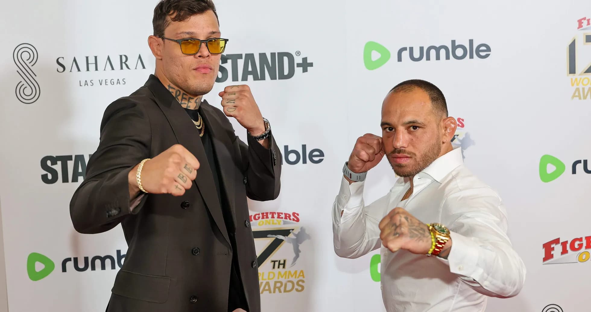 Two fighters posing with fists raised at event