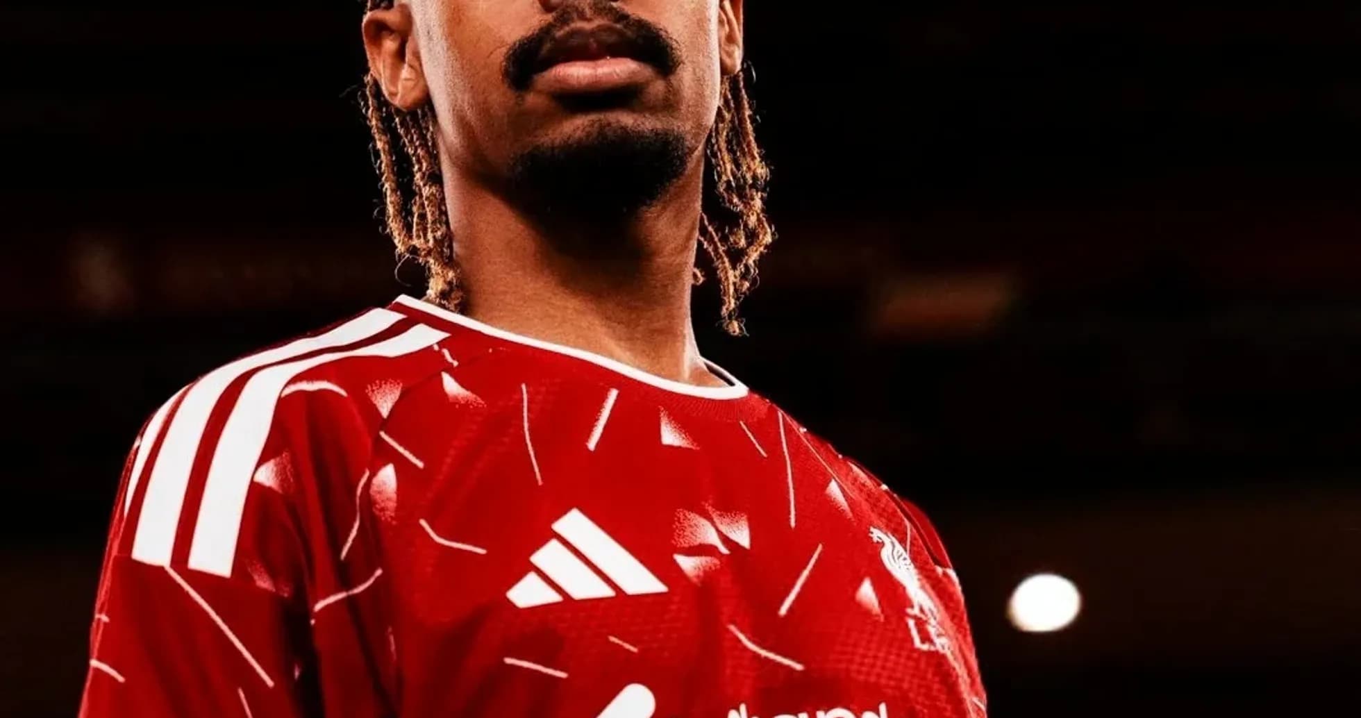 Player posing in red jersey with club logo