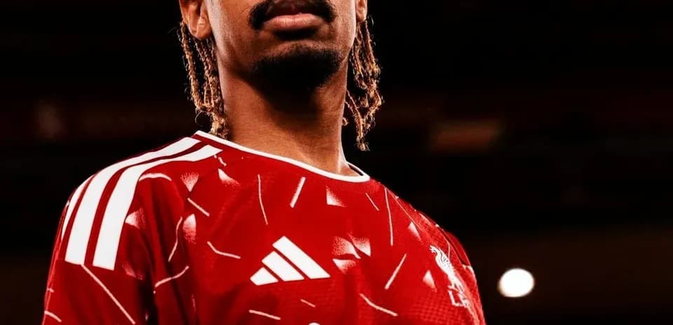 Player posing in red jersey with club logo