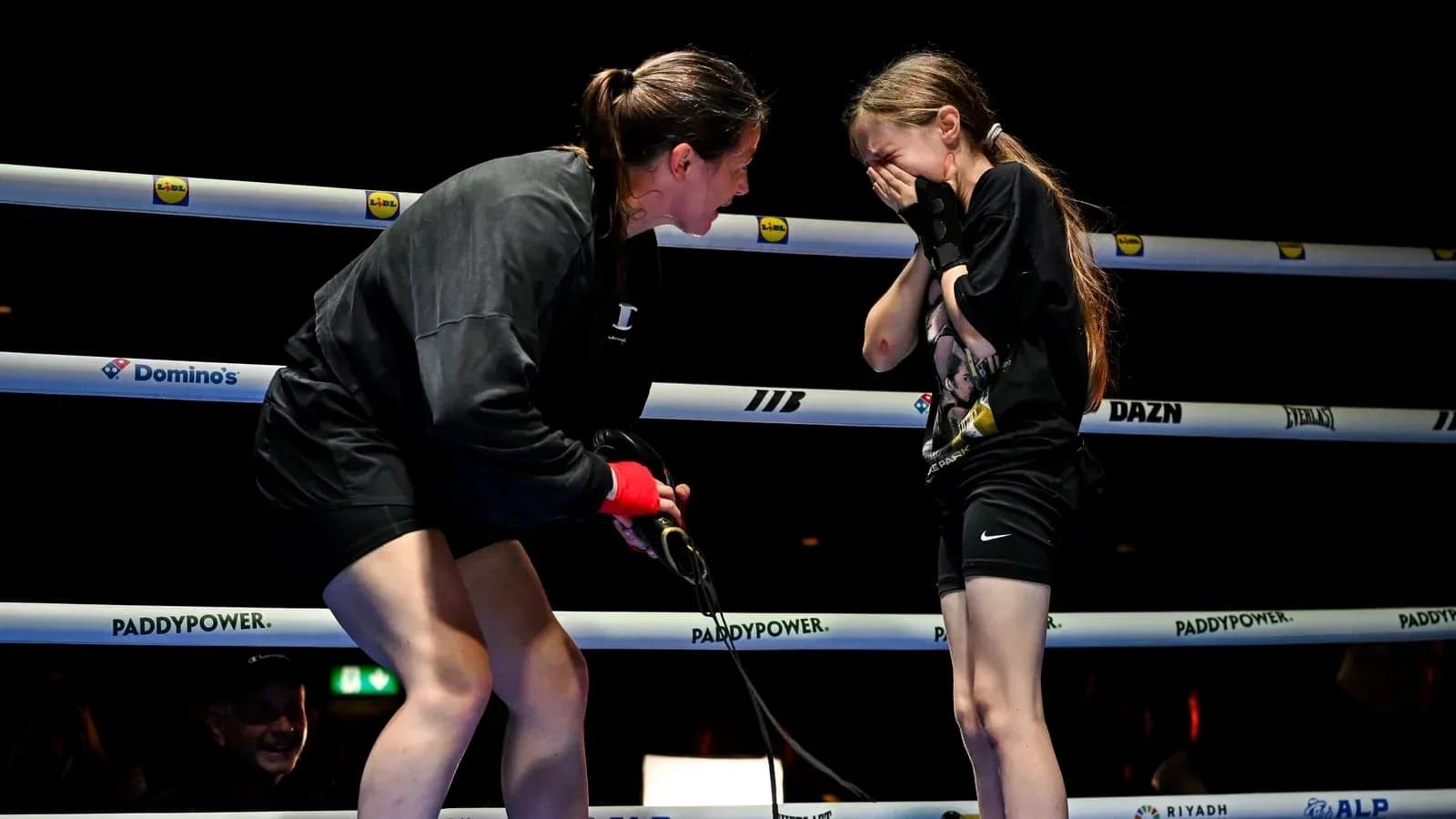 Boxer comforting a young girl in the ring