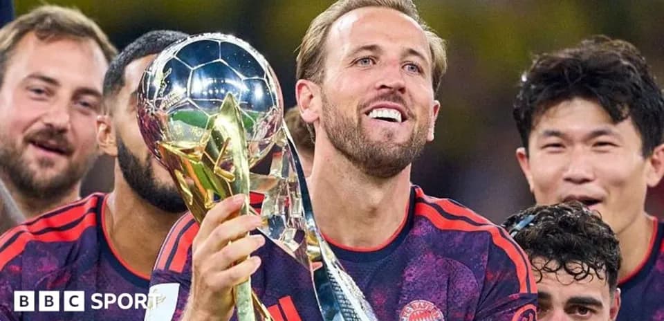 Player celebrating with trophy surrounded by teammates