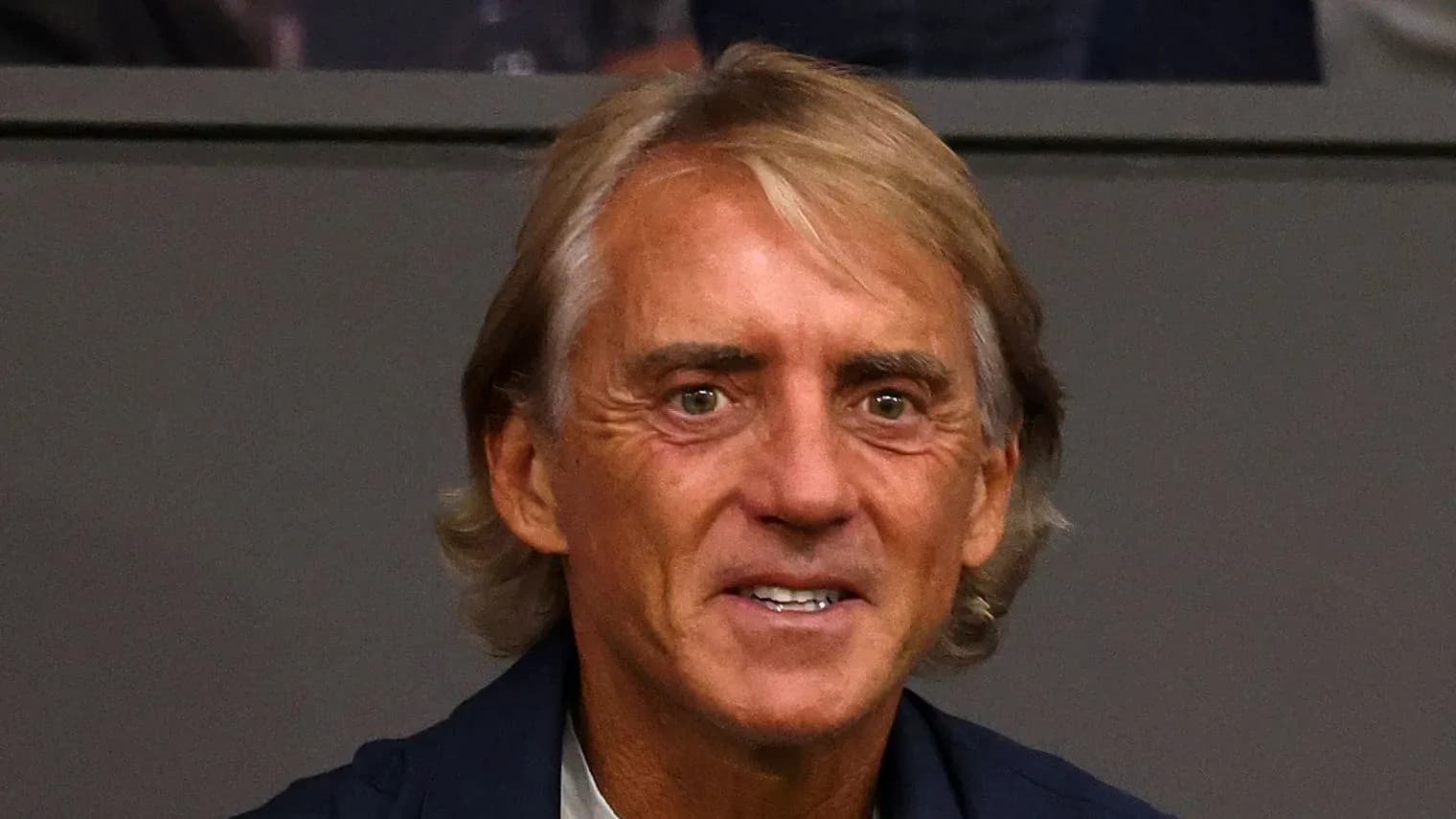 Man with blonde hair smiling at event