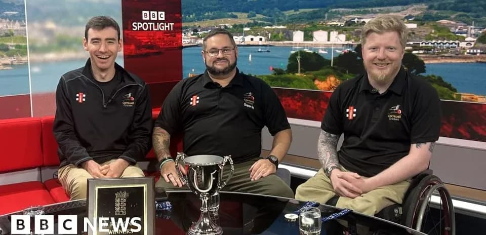 Three men with trophy on news studio set