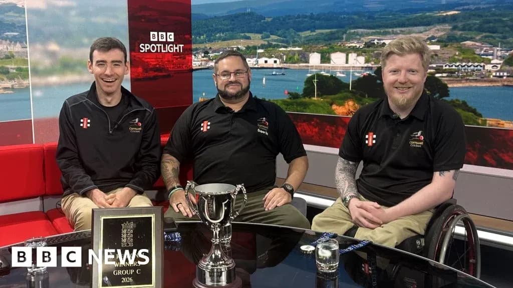 Three men with trophy on news studio set