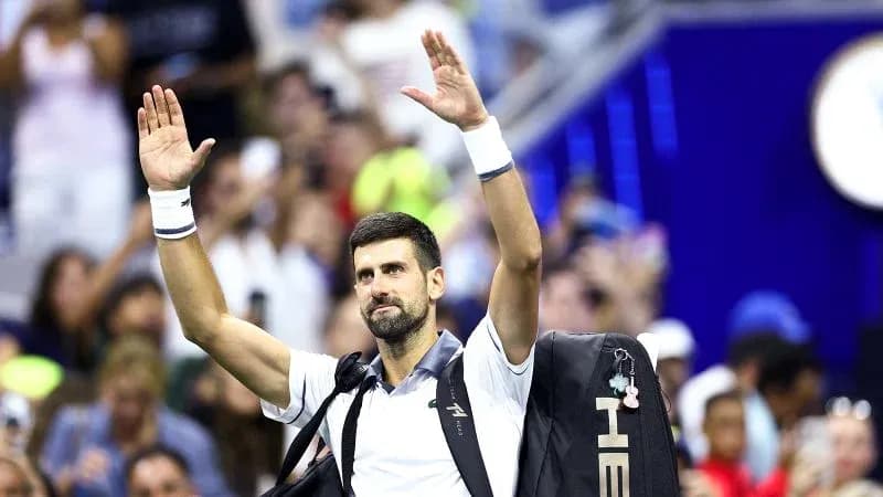 Tennis player waving to crowd after match