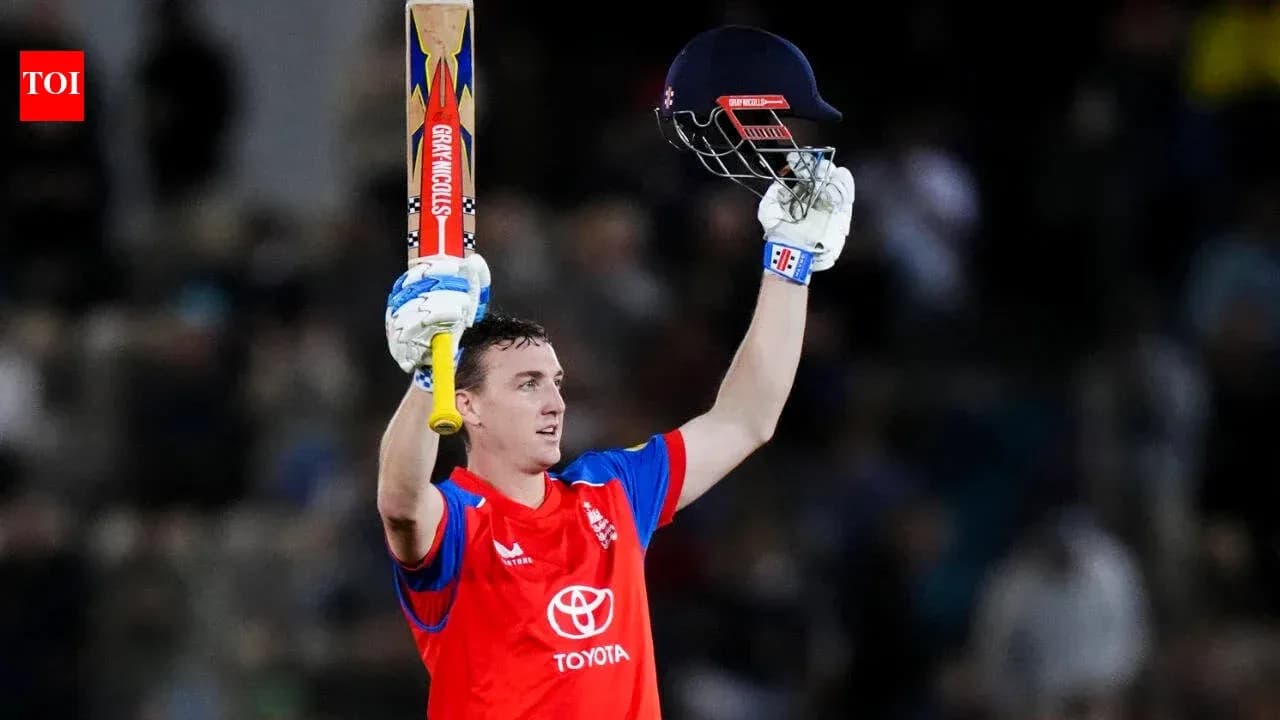 Batsman celebrating century with raised bat and helmet