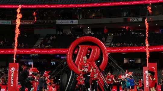 Players entering arena through inflatable tunnel with flames