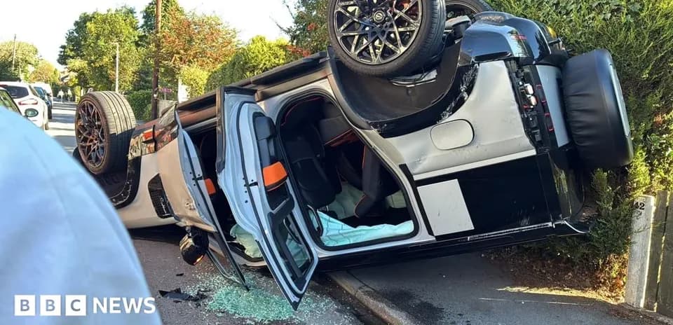 Upside-down car with shattered glass on road