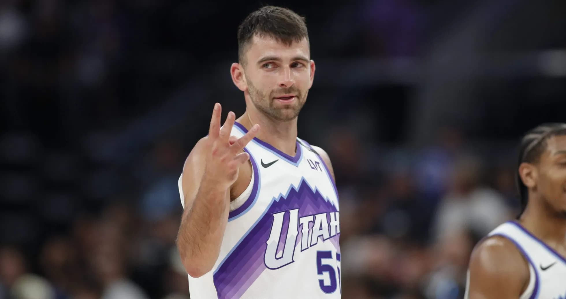 Player gesturing three points during basketball game