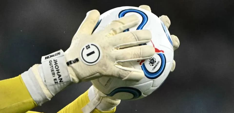 Goalkeeper catching a soccer ball with gloves