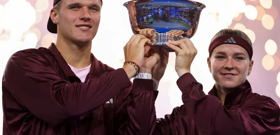 Athletes celebrating victory with trophy during ceremony