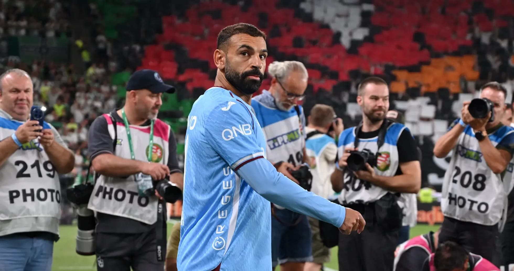 Player walking past photographers after match