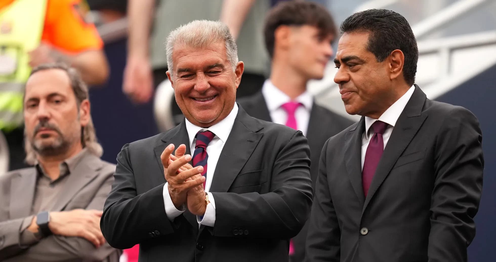 Two men in suits smiling and clapping together