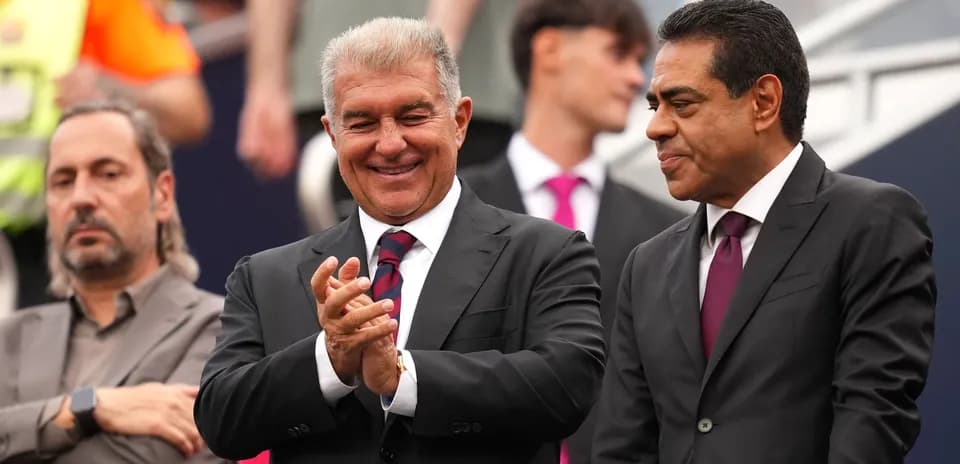 Two men in suits smiling and clapping together