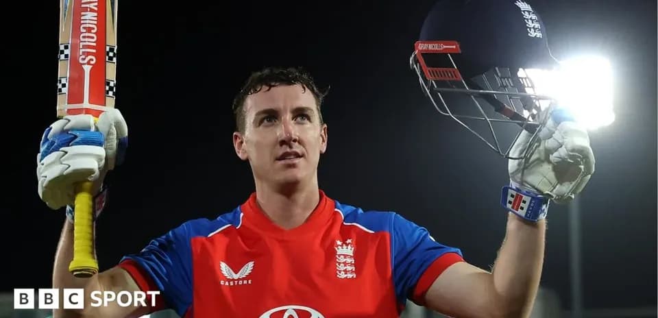 Batsman celebrating with bat and helmet raised