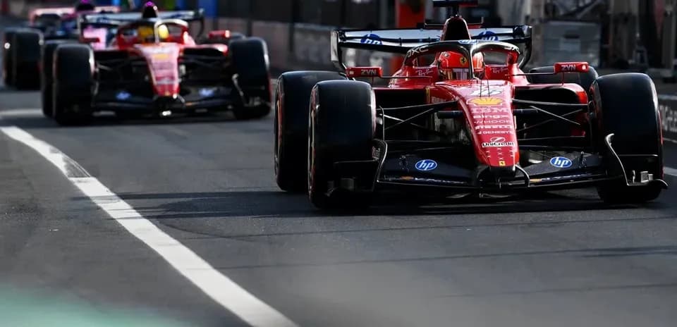 Two Ferrari cars racing on a track