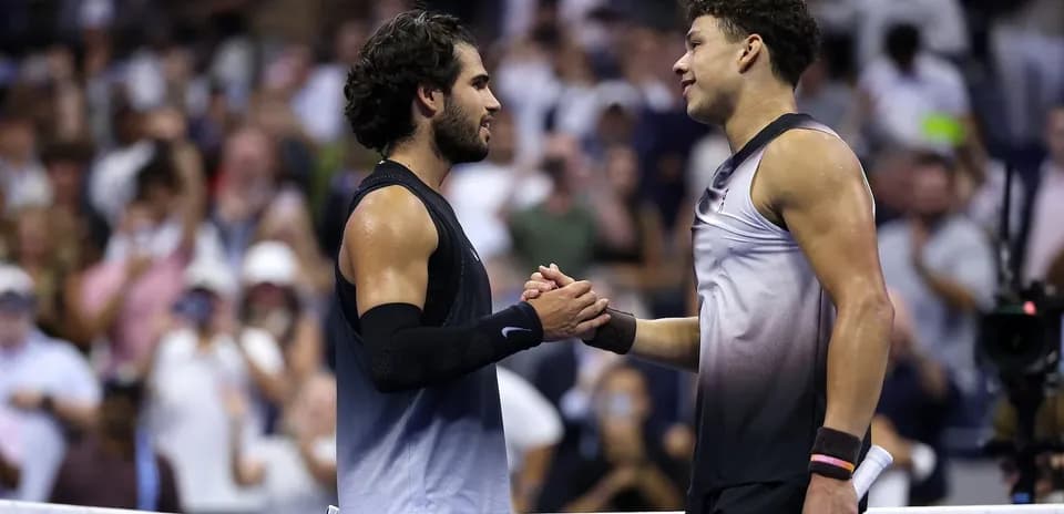 Two tennis players shaking hands at net