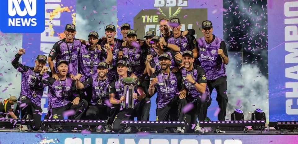 Cricket team celebrating victory with trophy on stage