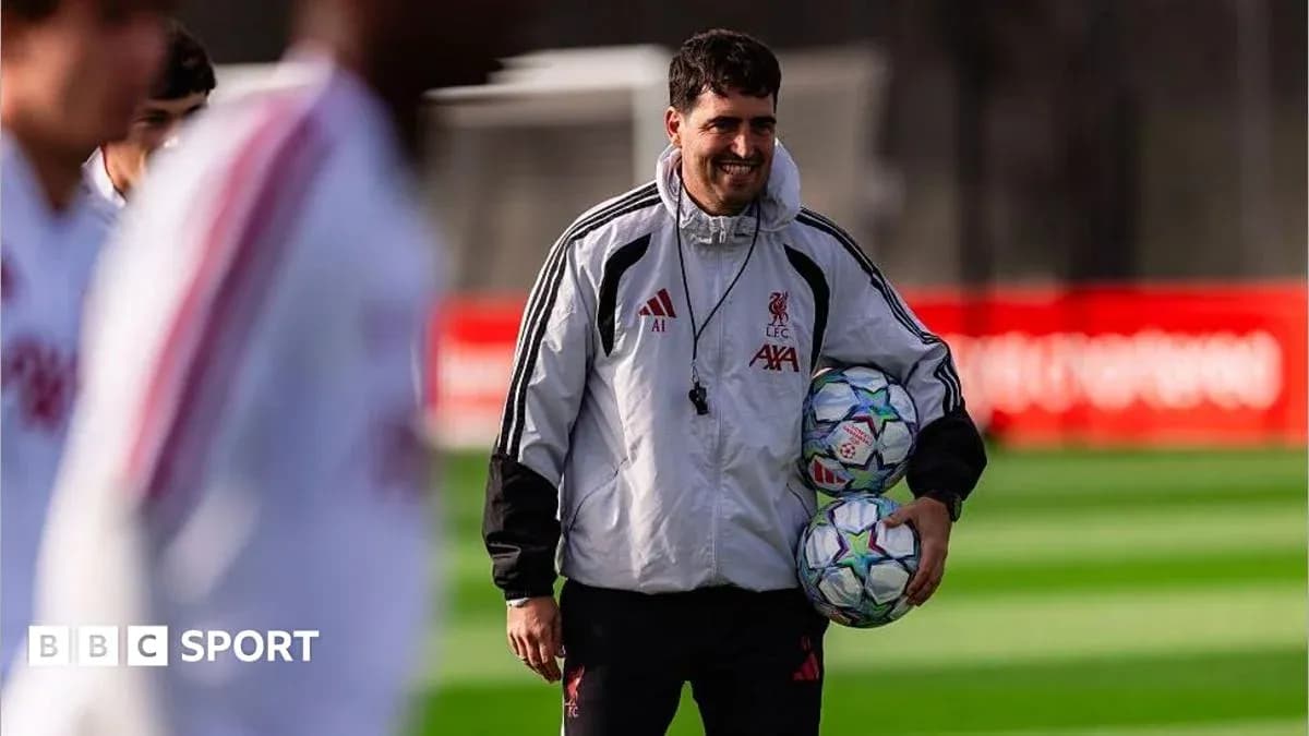 Coach carrying footballs during training session