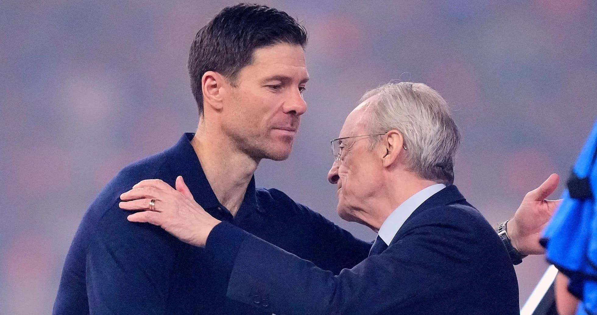 Two men embracing on a football pitch