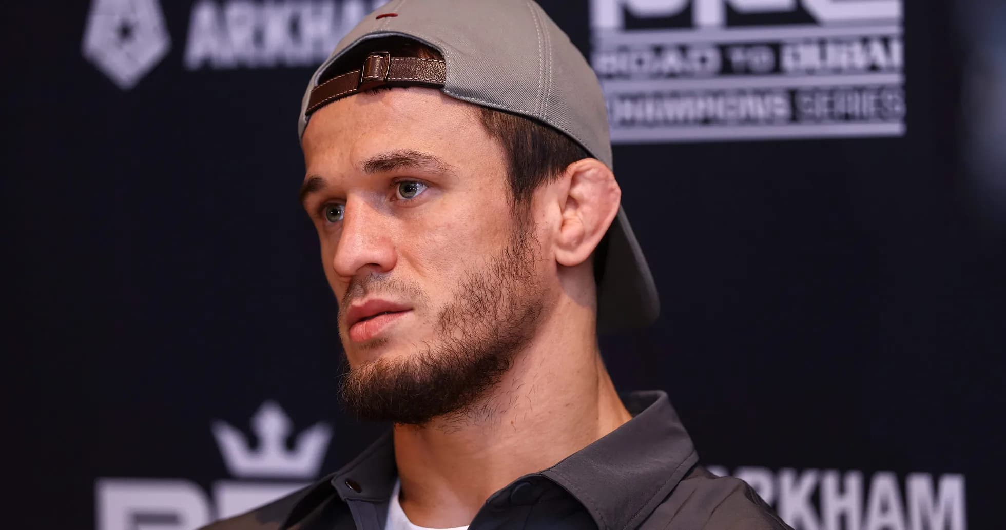 Fighter at press conference with cap and serious expression